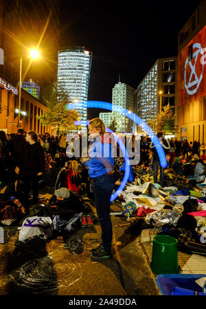 Berlin, Deutschland. 12 Okt, 2019. Eine junge Frau jongliert Bolas unter dem Logo der Bewegung der 'Aussterben Rebellion', während Umweltaktivisten Stresemannstraße vor dem Bundesministerium für Umwelt, Naturschutz und Reaktorsicherheit. Quelle: Stefan Jaitner/dpa/Alamy leben Nachrichten Stockfoto