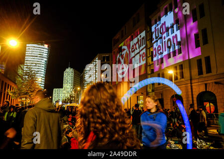 Berlin, Deutschland. 12 Okt, 2019. Eine junge Frau jongliert Bolas unter den Schriftzug und Logo der Bewegung der 'Aussterben Rebellion', während Umweltaktivisten Stresemannstraße vor dem Bundesministerium für Umwelt, Naturschutz und Reaktorsicherheit. Quelle: Stefan Jaitner/dpa/Alamy leben Nachrichten Stockfoto