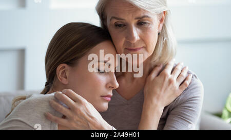 Liebevolle Sorge älter 60 s Mutter trösten traurig erwachsene Tochter Stockfoto