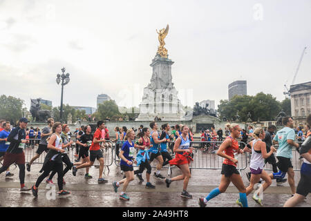 London, UK, 13. Oktober 2019. Die Teilnehmer laufen hinter Victoria Fountain und Buckingham Palace, als Hunderte von Läufern mit vielen Laufen Geld für wohltätige Organisationen zu erhöhen, nehmen an der Königlichen Parks Halbmarathon, in einen Kurs, der im Hyde Park, Green Park, St. James's Park und dem berühmten Wahrzeichen. Credit: Amer ghazzal/Alamy leben Nachrichten Stockfoto