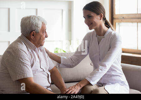 Alter Mann vorsichtig Krankenschwester oder Betreuer Kommunikation im Innenbereich Stockfoto