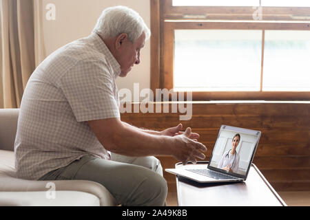 Älterer Mann fernen Videoanruf kommunizieren mit Doktor online stellen Stockfoto