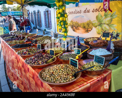 Breton Marktstand und Abschaltdruck Inhaber Verkauf einer Vielzahl von gesunden Oliven auf Display, in hölzernen Schüsseln Jardins du Soleil Auribeau sur Mer Bretagne Frankreich Stockfoto