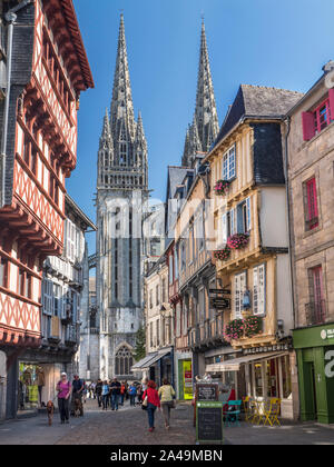 Quimper Bretagne Altstadt Rue Kereon Quimper Cathedral Turm im Hintergrund. Besucher genießen einen Spaziergang an der historischen Straße mit Kopfsteinpflaster. Quimper Frankreich Stockfoto