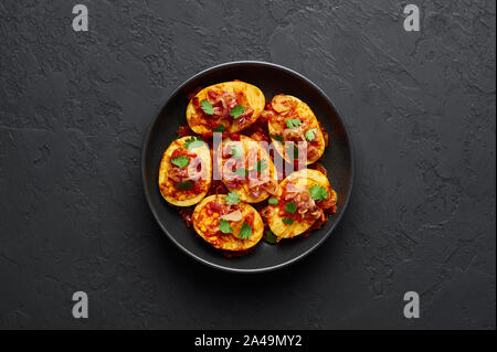 Goldene Ei Curry in schwarz Schüssel am dunklen Schiefer Hintergrund. Die burmesische Ei Curry ist beliebt Myanmar Küche Teller mit Ente oder Huhn Eier, Tomaten, Ingwer Stockfoto