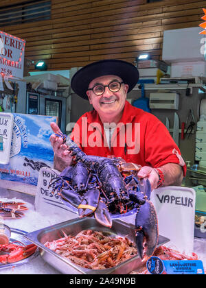 BRETON FISCHHÄNDLER & LIVE BLUE LOBSTER CLEUNES FISCH MARKTSTAND CONCARNEAU FRANKREICH BRETAGNE Concarneau täglich innen Französisch Fisch Markthalle und Charakter Fischhändler, im bretonischen Stil Outfit stolz seinen lokalen live Blue Lobster Anzeigen zum Verkauf bretagne finistere Frankreich Stockfoto