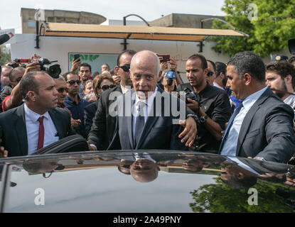 Tunis, Tunesien. 13 Okt, 2019. Unabhängige tunesische Präsidentschaftskandidat Kais Saied (C) grüsst Anhänger nach seiner Stimmabgabe vor einem Wahllokal in der zweiten Runde der tunesischen Präsidenten zwischen Präsidentschaftskandidaten Kais Saied und Nabil Karoui. Credit: Khaled Nasraoui/dpa/Alamy leben Nachrichten Stockfoto
