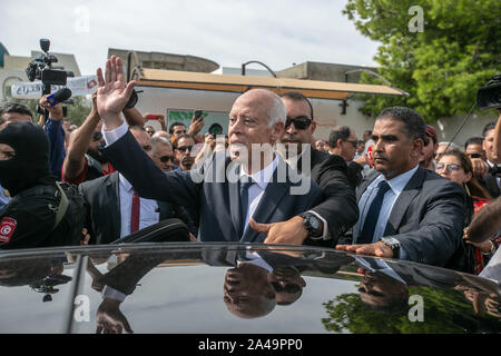 Tunis, Tunesien. 13 Okt, 2019. Unabhängige tunesische Präsidentschaftskandidat Kais Saied (C) grüsst Anhänger nach seiner Stimmabgabe vor einem Wahllokal in der zweiten Runde der tunesischen Präsidenten zwischen Präsidentschaftskandidaten Kais Saied und Nabil Karoui. Credit: Khaled Nasraoui/dpa/Alamy leben Nachrichten Stockfoto