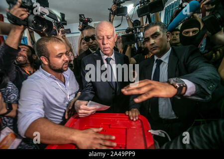Tunis, Tunesien. 13 Okt, 2019. Unabhängige tunesische Präsidentschaftskandidat Kais Saied (C) wirft seine Stimme in einem Wahllokal in der zweiten Runde der tunesischen Präsidenten zwischen Präsidentschaftskandidaten Kais Saied und Nabil Karoui. Credit: Khaled Nasraoui/dpa/Alamy leben Nachrichten Stockfoto