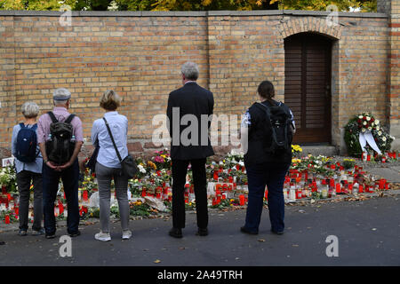 Halle, Deutschland. 13 Okt, 2019. Die Leute stehen vor Kerzen und Blumen, die in der Synagoge gelegt, vier Tage nach der Rechtsextremen Angriff auf die Gemeinde. Am 09.10.2019, wurden zwei Leute tot vor der Synagoge und in einem Kebab Snack bar geschossen während der Angriffe durch einen rechtsextremen Täter in Halle. Quelle: dpa Picture alliance/Alamy leben Nachrichten Stockfoto