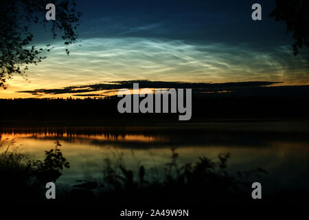 Beleuchtete Zirruswolken in der Abenddämmerung über dem See Malgomaj in Vasterbotten, Schweden. Stockfoto