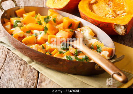 Herbst Kürbis Auflauf mit Mozzarella Käse und Kräutern close-up in einer Auflaufform auf den Tisch. Horizontale Stockfoto