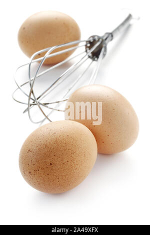 Rohe Eier mit einem Schneebesen isoliert auf weißem Stockfoto