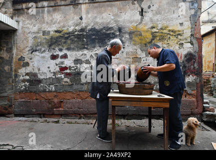 Poyang, der chinesischen Provinz Jiangxi. 12 Okt, 2019. Ding Guokun und sein Lehrling Arbeiten an seinem Haus in Poyang County, der ostchinesischen Provinz Jiangxi, Okt. 12, 2019. Ding Guokun, 76, ein auf nationaler Ebene immaterielles kulturelles Erbe Erbe, hat körperlosen Lackwaren, seit er 16 war. " Halten, zu tun, eine Sache und es gut. Sie werden schließlich die Anerkennung der Menschen verdienen", sagt Ding. Credit: Hu Chenhuan/Xinhua/Alamy leben Nachrichten Stockfoto