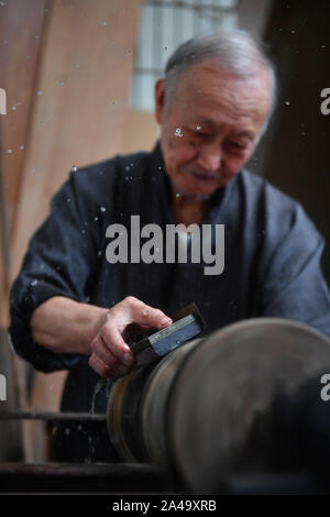 Poyang, der chinesischen Provinz Jiangxi. 12 Okt, 2019. Ding Guokun arbeitet auf einem Stück lackwaren an seinem Haus in Poyang County, der ostchinesischen Provinz Jiangxi, Okt. 12, 2019. Ding Guokun, 76, ein auf nationaler Ebene immaterielles kulturelles Erbe Erbe, hat körperlosen Lackwaren, seit er 16 war. " Halten, zu tun, eine Sache und es gut. Sie werden schließlich die Anerkennung der Menschen verdienen", sagt Ding. Credit: Hu Chenhuan/Xinhua/Alamy leben Nachrichten Stockfoto