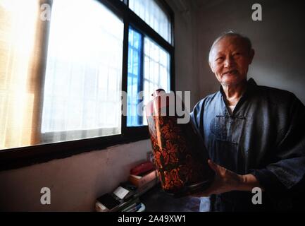 Poyang, der chinesischen Provinz Jiangxi. 12 Okt, 2019. Ding Guokun zeigt seine Arbeit an seinem Haus in Poyang County, der ostchinesischen Provinz Jiangxi, Okt. 12, 2019. Ding Guokun, 76, ein auf nationaler Ebene immaterielles kulturelles Erbe Erbe, hat körperlosen Lackwaren, seit er 16 war. " Halten, zu tun, eine Sache und es gut. Sie werden schließlich die Anerkennung der Menschen verdienen", sagt Ding. Credit: Hu Chenhuan/Xinhua/Alamy leben Nachrichten Stockfoto