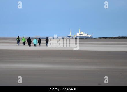 Spaziergänger auf Bamburgh Strand, in Blasen von Sand, Northumberland Stockfoto