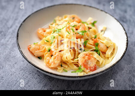 Nahaufnahme von Garnelen Fettuccine Alfredo auf blauem Hintergrund Stockfoto