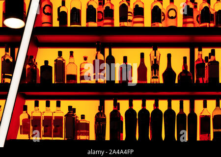 Flaschen im Regal sitzen in einer Bar, Rot Neon blacklight Stockfoto