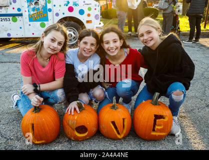 Chicago, USA. 12 Okt, 2019. Vier Mädchen Zauber 'Liebe' mit geschnitzten Kürbis beim Kürbisfest in Highwood, Illinois, USA, am Okt. 12, 2019. Quelle: Joel Lerner/Xinhua/Alamy leben Nachrichten Stockfoto