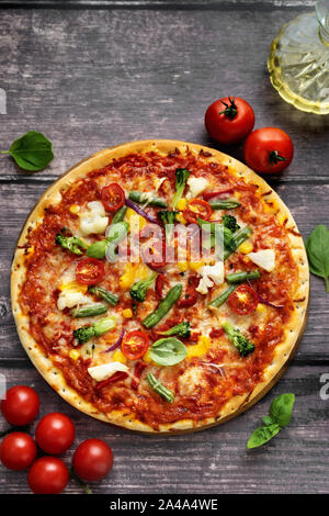 Blick von oben auf die vegetarische Pizza serviert auf Holztisch im rustikalen Stil Stockfoto