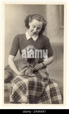 Anfang des 20. Jahrhunderts Studio Porträt von jungen Frau / Teenager-Mädchen trägt einen kurzen Ärmel gestrickt Pullover, mit einem Haustier Cocker Spaniel, um 1937, Großbritannien Stockfoto