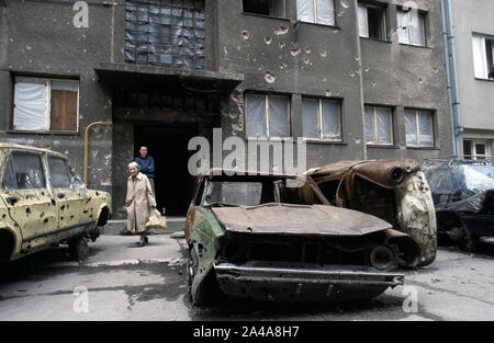 5. Juni 1993 während der Belagerung von Sarajevo: Zwei Frauen chat Neben Autowracks in Kralja Tvrtka Straße, am westlichen Rand der Innenstadt. Die Straße ist in direkter Linie mit dem belagerten bosnischen Serben, kaum 300 Meter entfernt. Stockfoto