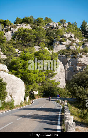 Weibliche Radfahrer Radfahren durch die Alpilles, ganz in der Nähe San Remy, Frankreich. Stockfoto