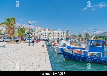 Ermioni Griechenland - 20 Juli 2019; Waterfront mit seinen malerischen Fischerbooten günstig an Pier und die Promenade und die Stadt Gebäude hinter. Stockfoto