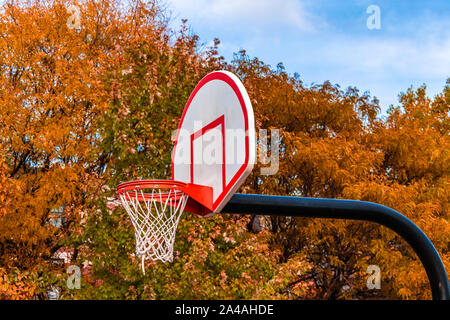 Basketball Hoop Side View mit Herbstbäumen im Hintergrund Stockfoto