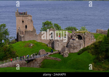 Touristen besuchen die Ruine des Urquhart Castle in der Nähe von Drumnadrochit am Ufer des Loch Ness, Inverness-shire Schottland Großbritannien Stockfoto