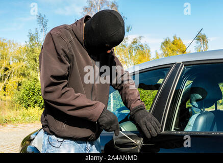 Autodieb in Aktion auf einem Auto Stockfoto