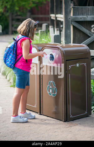 Mädchen der Hinterlegung einer Plastikflasche in einem speziellen recycling Container Stockfoto