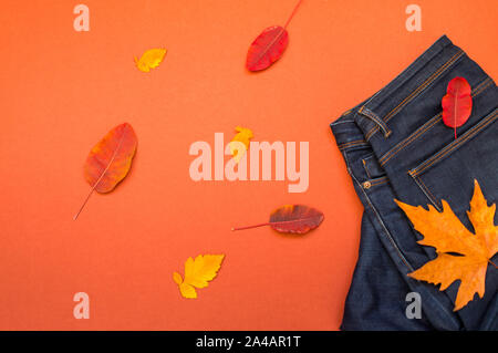 Weibliche Herbst outfit Blue sweter und Jeans auf einem terracote Hintergrund, Ansicht von oben. Winter, Herbst Bekleidung Stockfoto