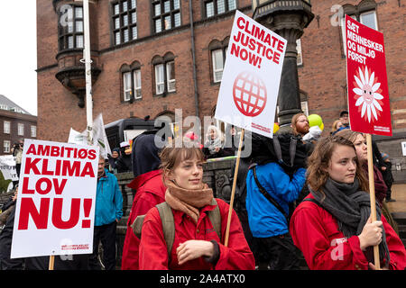 Kopenhagen, Dänemark - Oktober 11, 2019: Tausende von Menschen versammeln sich die Leute Klima März im Kopenhagener Rathaus Platz und forderte rasche und umfangreiche Klimapolitik, die den Abschluss der C40-Welt Bürgermeister Gipfel in dieser Woche in Kopenhagen. Auf der linken Seite ein Schild mit dem Text in englischer Sprache: "ehrgeizige Klima Gesetz jetzt'. Dies bezieht sich auf eine beliebte Forderung nach einer gesetzlichen Rahmenbedingung für die Bemühungen der dänischen Regierung Klima, die enthält Verpflichtungen für verbindliche Klimaschutzziele zu definieren. Stockfoto