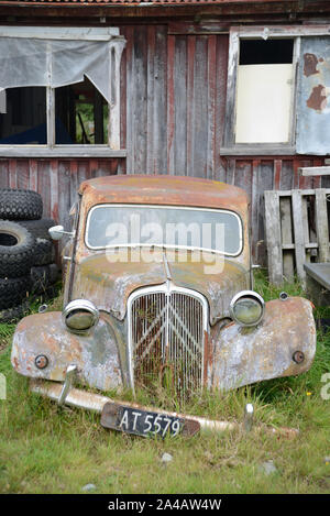 Ein verlassenes Auto liegt neben einer alten Scheune in Neuseeland Stockfoto