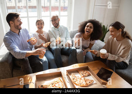 Gerne diverse Freunde essen Pizza, sich gemeinsam amüsiert Stockfoto