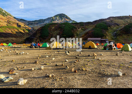 Campingplatz und Paar bunte Zelte sind im Tal. Menschen sind die Zubereitung von Speisen zum Abendessen auf der Wandern. Aktivitäten im Freien. Stockfoto