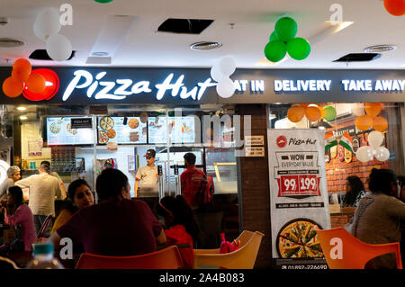 Masse der Leute draußen sitzen ein Pizza Hut in Indien Asien Stockfoto