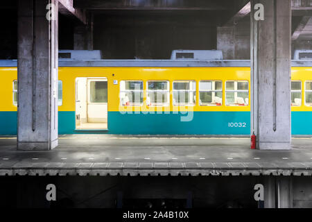 Offene Tür des Zuges. Gelb-blau grün Trainer und Bahnhof und Plattform. Stockfoto