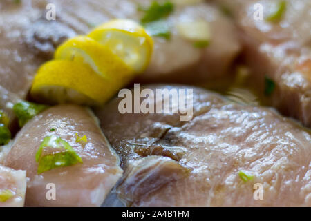 Marinierte Schwertfisch in einer Schüssel mit Zitronensaft, Öl, Knoblauch, Petersilie Stockfoto