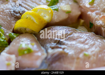 Marinierte Schwertfisch in einer Schüssel mit Zitronensaft, Öl, Knoblauch, Petersilie Stockfoto