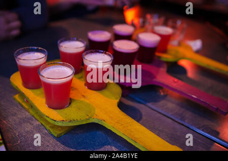 Rot transparent Cocktails, eine Reihe von Aufnahmen in einer Zeile. Vier Portionen auf einem Stand aus Holz Stockfoto