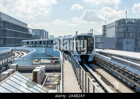 Die Monorail Bahn Nähert sich Station an einem sonnigen Tag. Die weißen U-Bahn anreisen, um die Plattform auf Open Air Track in Tokio, Japan. Stockfoto