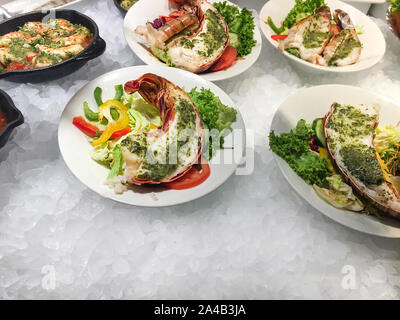 Köstliche Meeresfrüchte, Hummer mit Pesto und Knoblauch, chrimps, große Garnelen mit frischem Gemüse auf dem Bett von kaltem Eis. Stockfoto