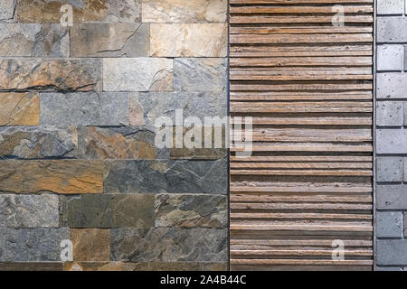 Die texturierte Wand durch Beton Ziegel, Holzbohlen und Naturstein Fliesen. Stockfoto