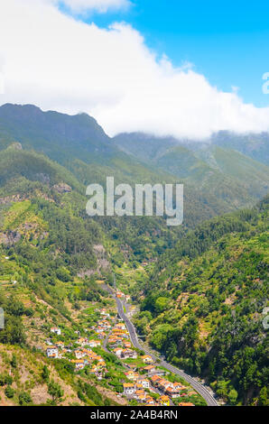 Herrliche Aussicht auf den malerischen Dorf Serra de Aqua auf der Insel Madeira, Portugal. Eine kleine Stadt in einem Tal umgeben von Bergen bedeckt. Durch grünen Wald. Portugiesische Landschaft. Touristische Attraktion. Stockfoto