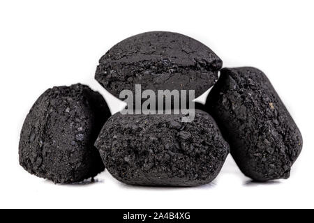 Briketts zum Grillen von Fleisch verwendet werden. Gedrückt Kohle für das Rauchen in den Grill. Hellen Hintergrund. Stockfoto