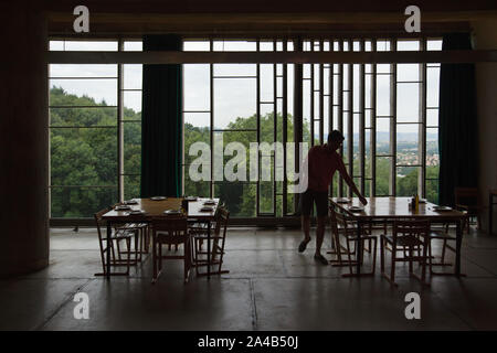 Man Geschirr in der klösterlichen Refektorium im Kloster von Sainte Marie de la Tourette entworfen von Schweizer modernistischen Architekten Le Corbusier (1959) in Éveux in der Nähe von Lyon, Frankreich. Stockfoto