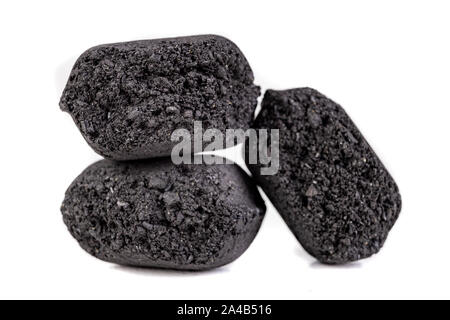 Briketts zum Grillen von Fleisch verwendet werden. Gedrückt Kohle für das Rauchen in den Grill. Hellen Hintergrund. Stockfoto
